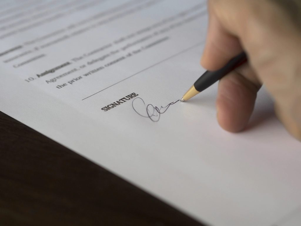 Una mano firmando un contrato